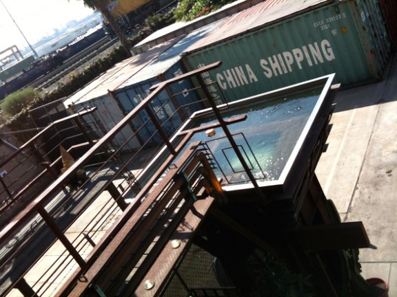 An elevated hot tub overlooking a nearby railyard